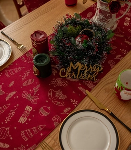 Christmas table runner detail with festive HO HO HO patterns and holiday decorations