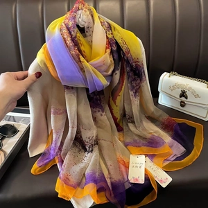 Detailed view of colorful gradient chiffon scarf on clothing with stylish fashion props