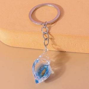 Close-up of a blue glowing conch shell keychain with resin texture and silver metal ring