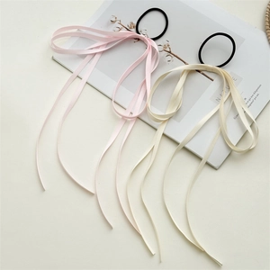 Pink and beige long ribbon bow hair ties with high elasticity bands on a white desk
