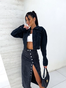 Détail d'une jupe midi en jean noir à taille haute avec fente irrégulière boutonnée