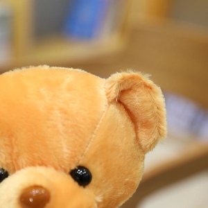 Detalle macro de osito de peluche naranja suave con textura de piel fina