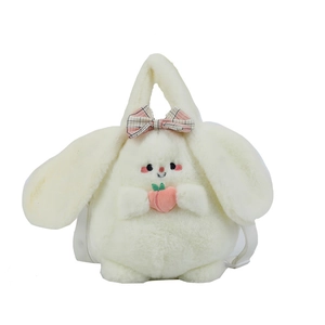 Plush bunny crossbody bag in cream white with pink bow holding a peach on white background