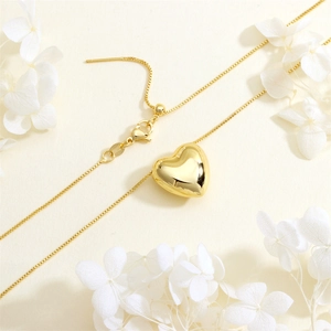 Detail of gold heart pendant with adjustable box chain and mirror-polished finish