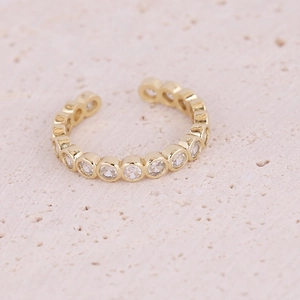 Close-up of golden heart ring with micro-pave white zircon inlay on stone surface