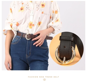 Detail of round metal pin buckle on a stylish faux leather belt for women's fashion