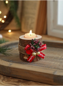Macro view of rustic wooden Christmas candle holder with red bow and gold bells detail