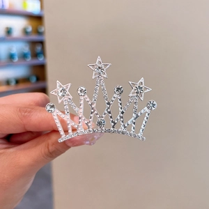 Detailed close-up of a silver crown hair comb with stars and sparkling rhinestones