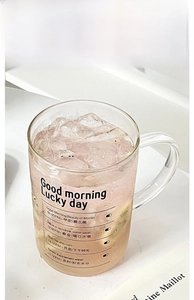 Detail view of transparent glass mug with handle and black time markings for hydration