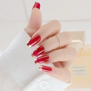 Fashionable red square press-on nails with gold French tips and twisted gold ring