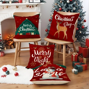 Detailed view of four red Christmas pillow covers with reindeer and snowman prints
