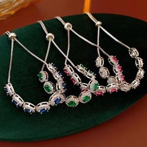 Détail macro de quatre bracelets argentés avec zircons colorés et fermoir coulissant ajustable