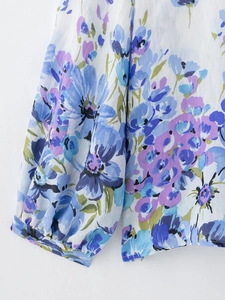 Detailed macro shot of floral print blouse showing elastic lantern sleeve cuff and hem