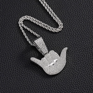 Macro shot of silver hip hop hand gesture pendant with sparkling rhinestones and chain