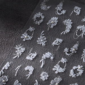 Stickers à ongles en dentelle blanche avec perles 3D et rubans sur fond sombre