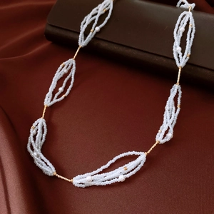 Bohemian multi-strand white seed bead necklace with gold spiral tube accents