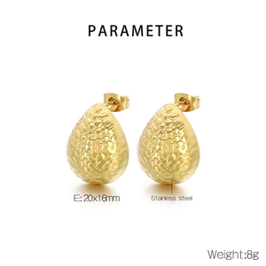 Detail view of gold teardrop earrings with hammered texture and stainless steel finish