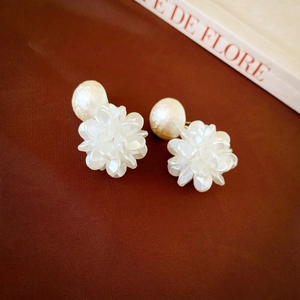 Gros plan de boucles d'oreilles fleurs élégantes avec perles d'imitation blanches