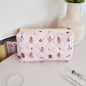 Detailed view of pink quilted storage bag with happy bear prints and white zipper
