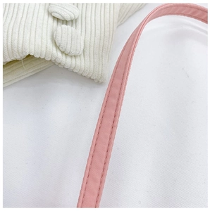 Close-up of pink nylon shoulder strap featuring durable reinforced double stitching detail