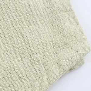 Detail view showing light green linen blend fabric texture and high-density plain weave pattern
