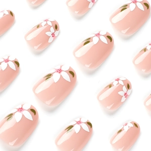 Pink press-on nails with white floral patterns and glossy finish on a white background