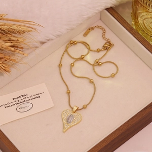 Two-tone gold heart pendant necklace with micro-paved zircons and religious relief