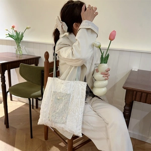 Detailed close-up of ivory lace tote bag featuring intricate embroidery and texture