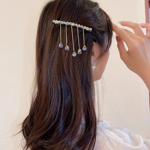 Detail of crystal tassel hair clip showing gradient chains with iridescent teardrop beads