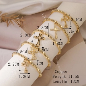 Detail showing gold copper beaded bracelets with micro-pave zircon cross pendants