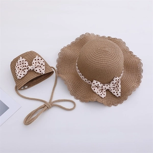Close-up of kids straw hat and matching bag with red polka dot bows and lace edges