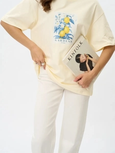 Detailaufnahme von Zitronen- und Blumenprint auf Baumwoll-T-Shirt mit Textdetail