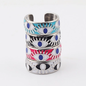 Macro shot of colorful enamel evil eye rings in light blue, black, and rose gold finish