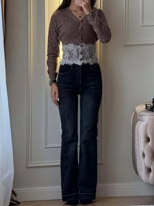Nahaufnahme der braunen Strickjacke mit weißem Spitzeneinsatz an der Taille und V-Ausschnitt