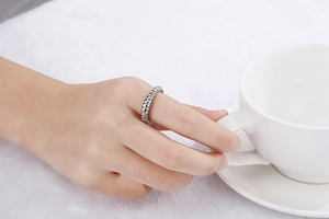 Detailed view of silver croissant dome ring with textured design worn on index finger