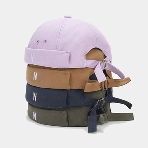 Close-up of retro dock caps in four colors featuring N embroidery and metal adjustment buckles
