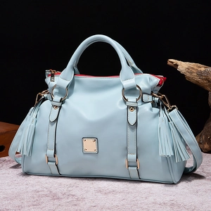 Bolso bandolera vintage azul claro con borlas laterales y herrajes metálicos dorados