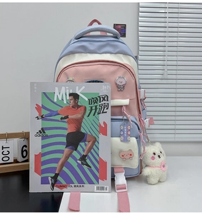 Pink and blue backpack detail with cute charms and badges on a desktop setting