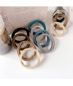 Close-up of elastic hair ties in neutral earth tones scattered on a minimalist desk