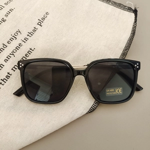 Close-up of UV400 kids square sunglasses on canvas bag in a soft lifestyle setting