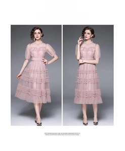 Détail d'une robe rose en tulle à volants avec manches bouffantes et broderie dentelle