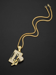Close-up of gold hip hop pendant with cassette and microphone covered in pavé crystals