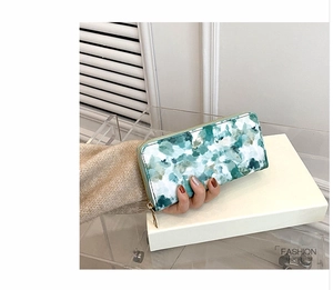 Detail of a green abstract marble pattern long wallet for women with golden zipper