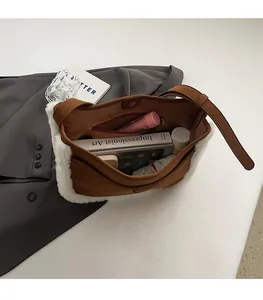 Detailed interior of brown suede bucket bag showing large capacity and zipper pocket