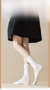 Close-up of white combed cotton mid-tube socks with soft ribbed texture and seamless toe