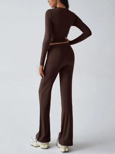 Rear view of woman in brown Y2K slim long sleeve crop top and high waist flared trousers set
