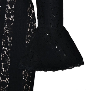 Dettaglio ravvicinato del tessuto in pizzo nero e dell'elegante manica a campana dell'abito