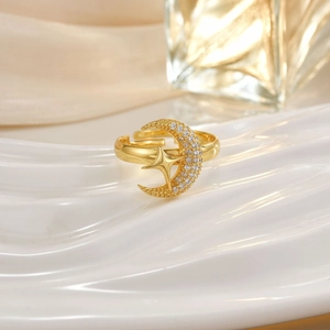 Macro shot of gold crescent moon and star ring with small embedded clear gemstones