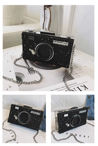 Detail of black camera-shaped crossbody bag with sequin stars and chain strap