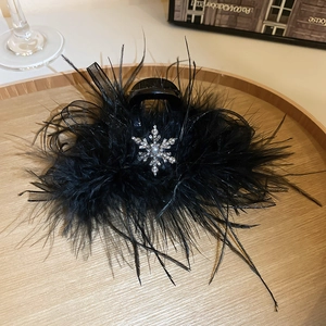 Vue détaillée d'une pince à cheveux en plumes noires avec ornements de flocons de strass